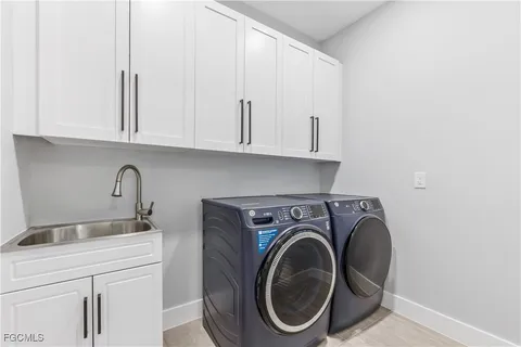 a utility room with sink dryer and washer
