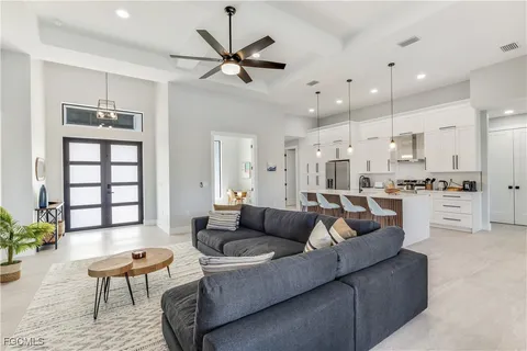 a living room with furniture kitchen and a chandelier