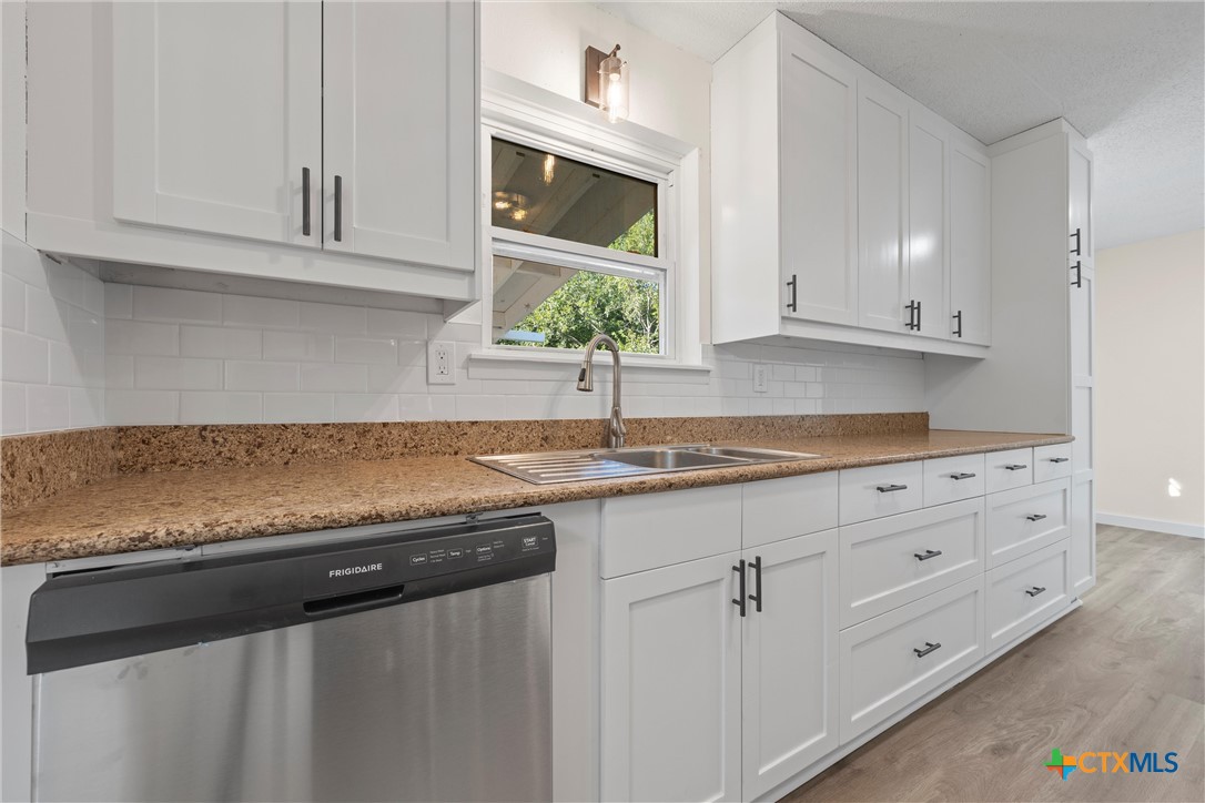 914 Edwards Street Copperas Cove, TX 76522 - Photo 2 of 13 a kitchen with granite countertop white cabinets and a sink