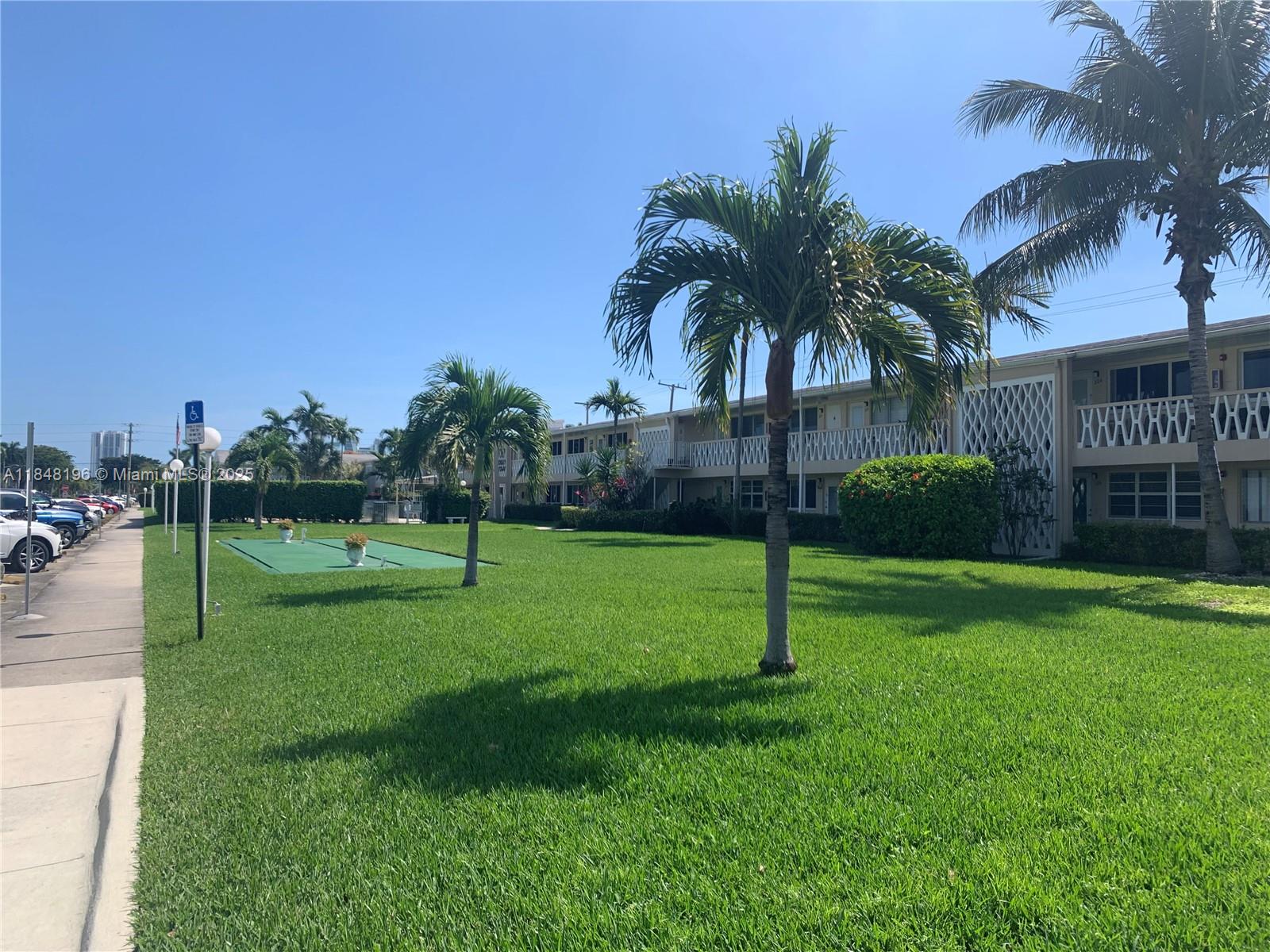 900 Atlantic Shores Boulevard, Unit 215 Hallandale Beach, FL 33009 - Photo 45 of 58 a view of a garden and palm trees