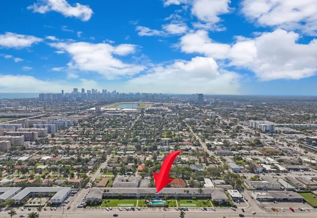 a view of a big house with a big yard and a large tree