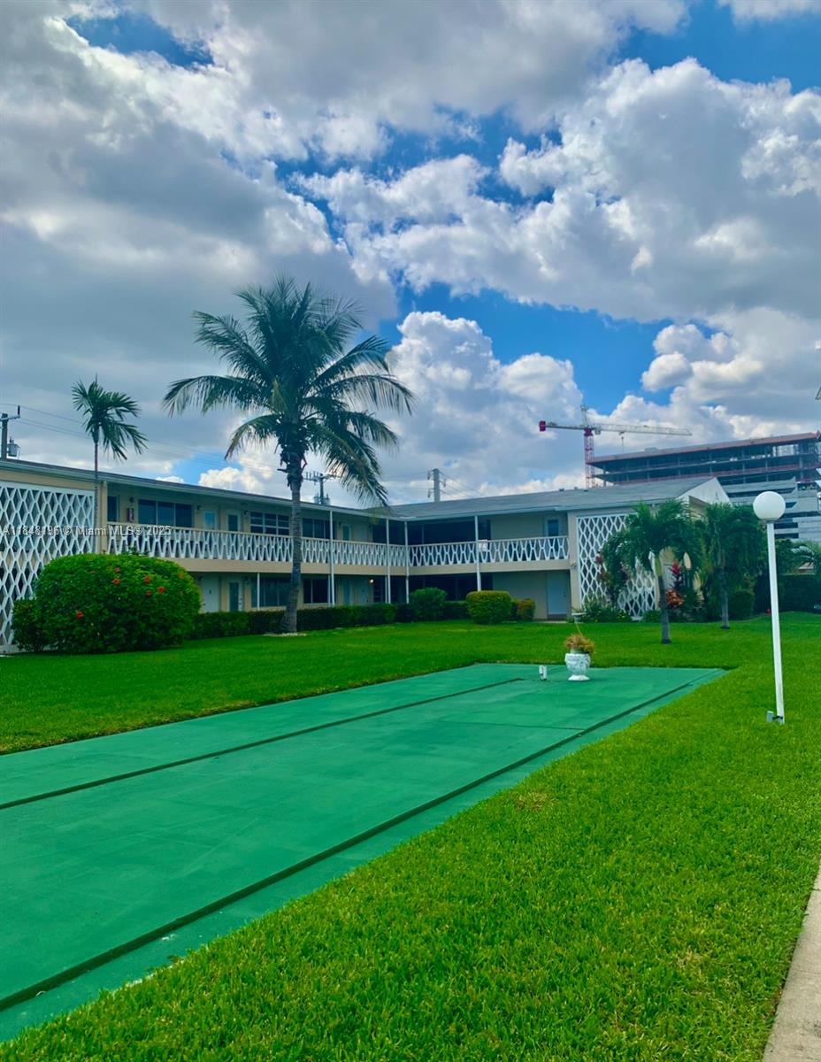 900 Atlantic Shores Boulevard, Unit 215 Hallandale Beach, FL 33009 - Photo 58 of 58 a view of a big house with a big yard and a large tree