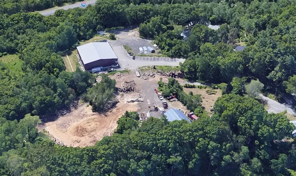 an aerial view of residential house with outdoor space and trees all around