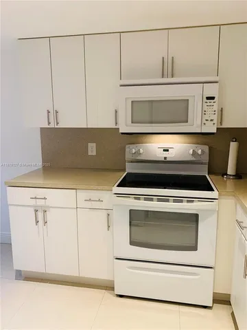 a stove top oven sitting inside of a kitchen