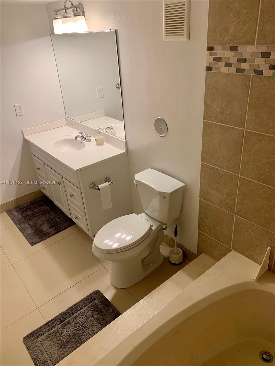 16500 Golf Club Road, Unit 101 Weston, FL 33326 - Photo 22 of 44 a bathroom with a sink a toilet and mirror