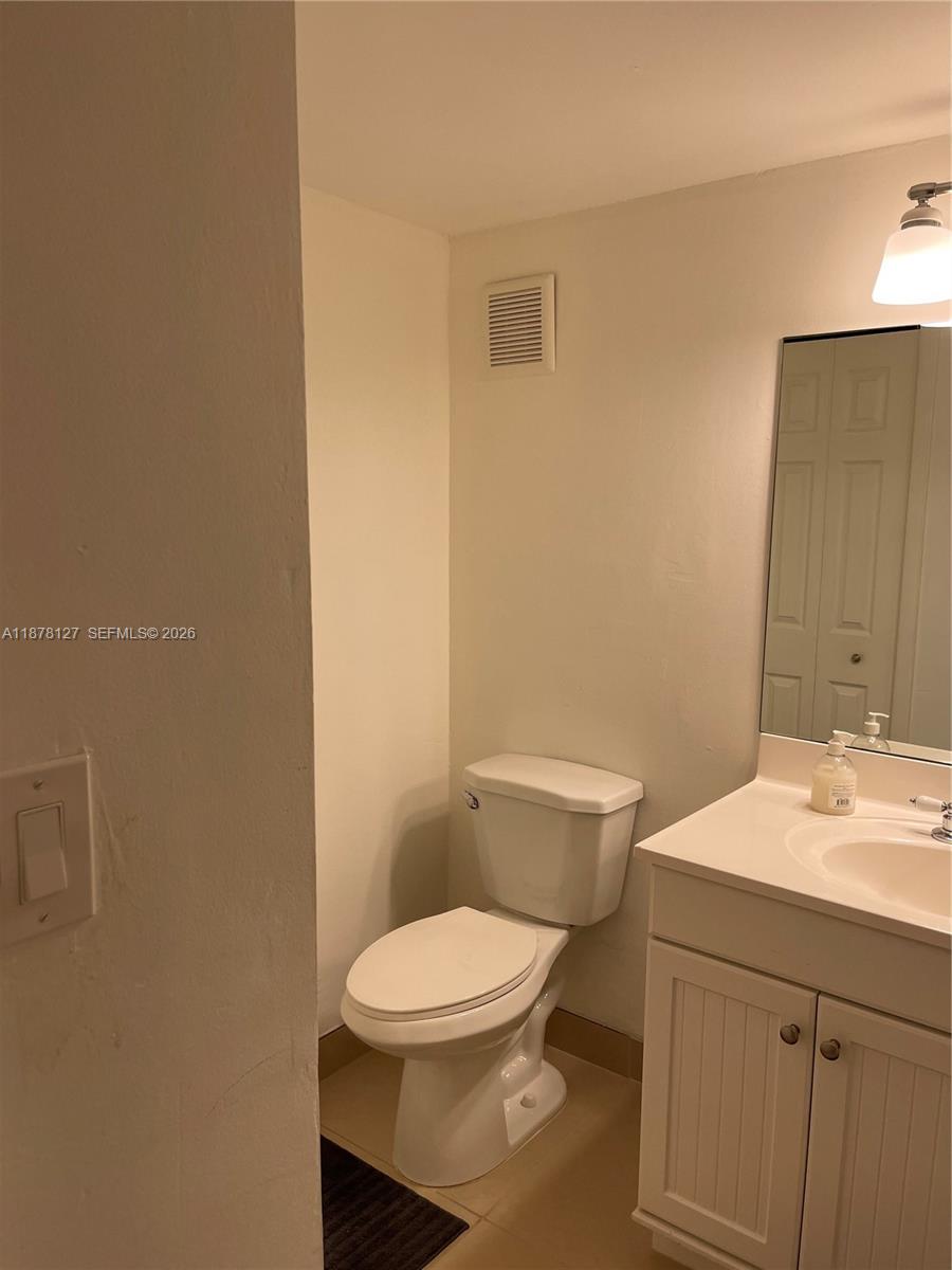 16500 Golf Club Road, Unit 101 Weston, FL 33326 - Photo 25 of 44 a bathroom with a toilet a sink and mirror