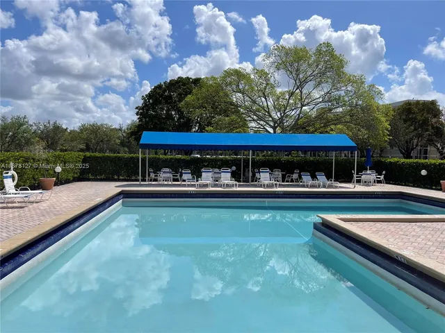 swimming pool view with a seating space
