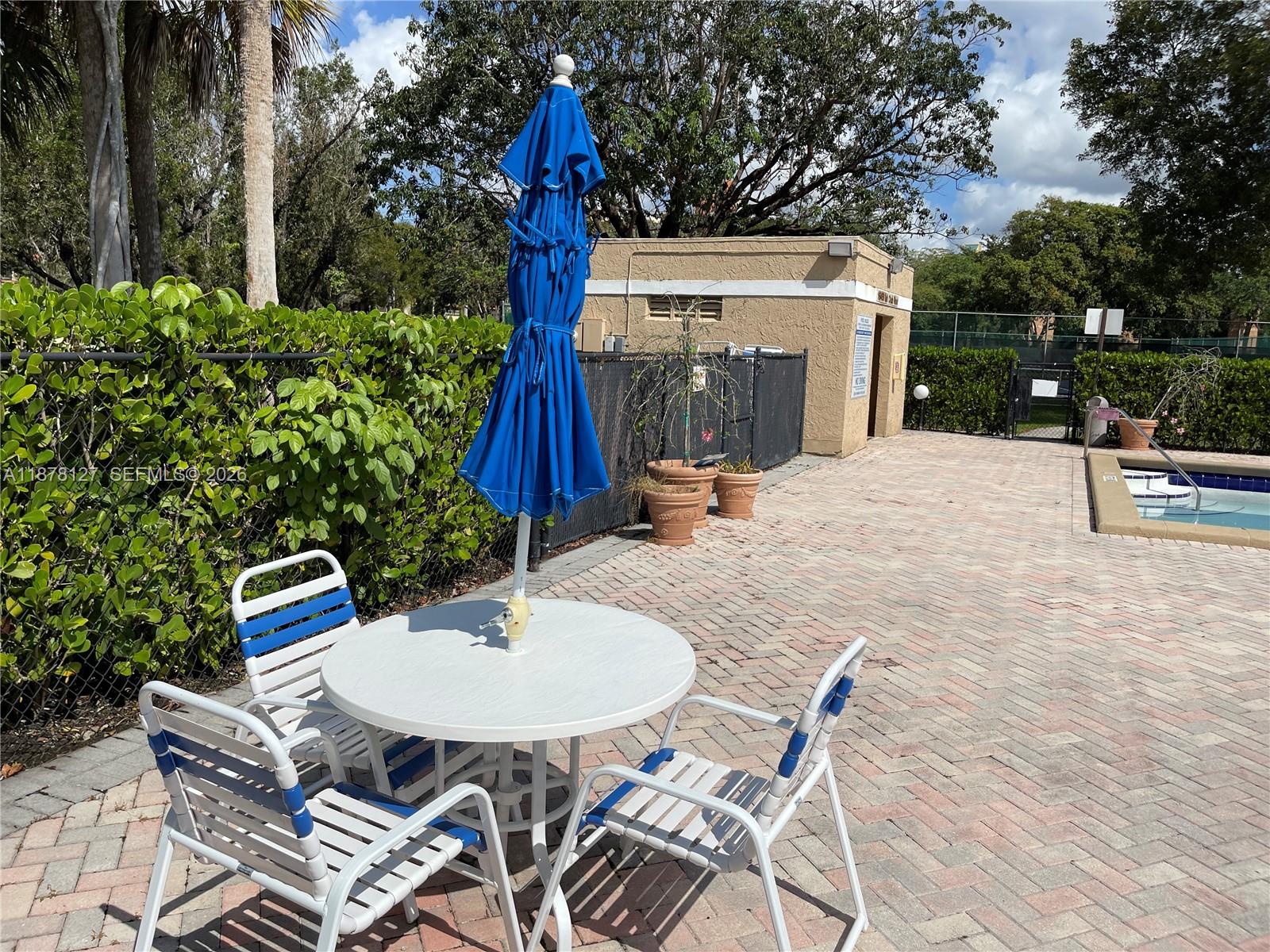 16500 Golf Club Road, Unit 101 Weston, FL 33326 - Photo 33 of 44 a backyard of a house with table and chairs