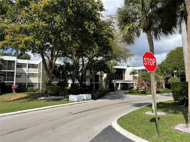 a view of a house with a yard and potted plants