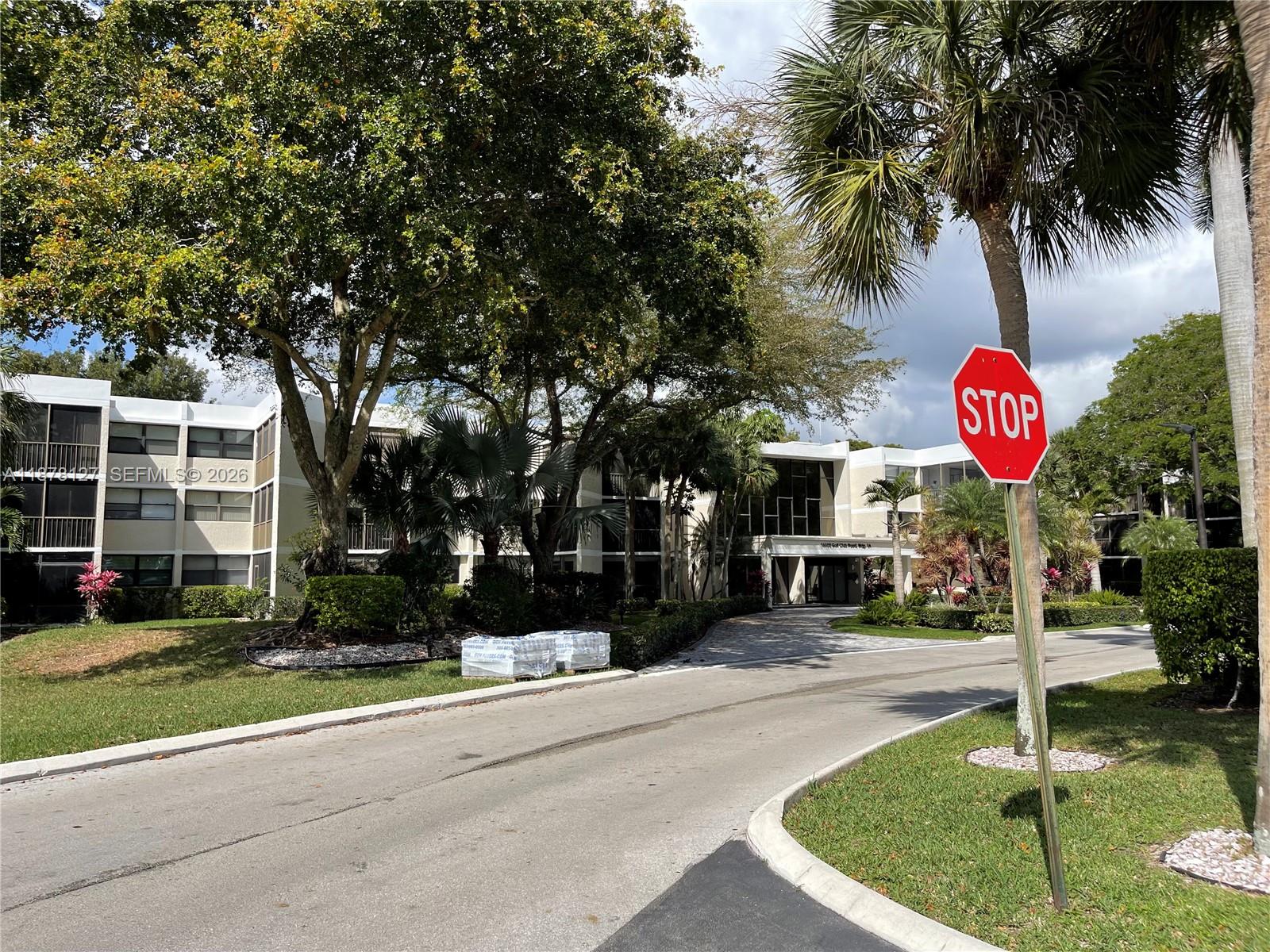 16500 Golf Club Road, Unit 101 Weston, FL 33326 - Photo 35 of 44 a front view of a house with a yard and tree s