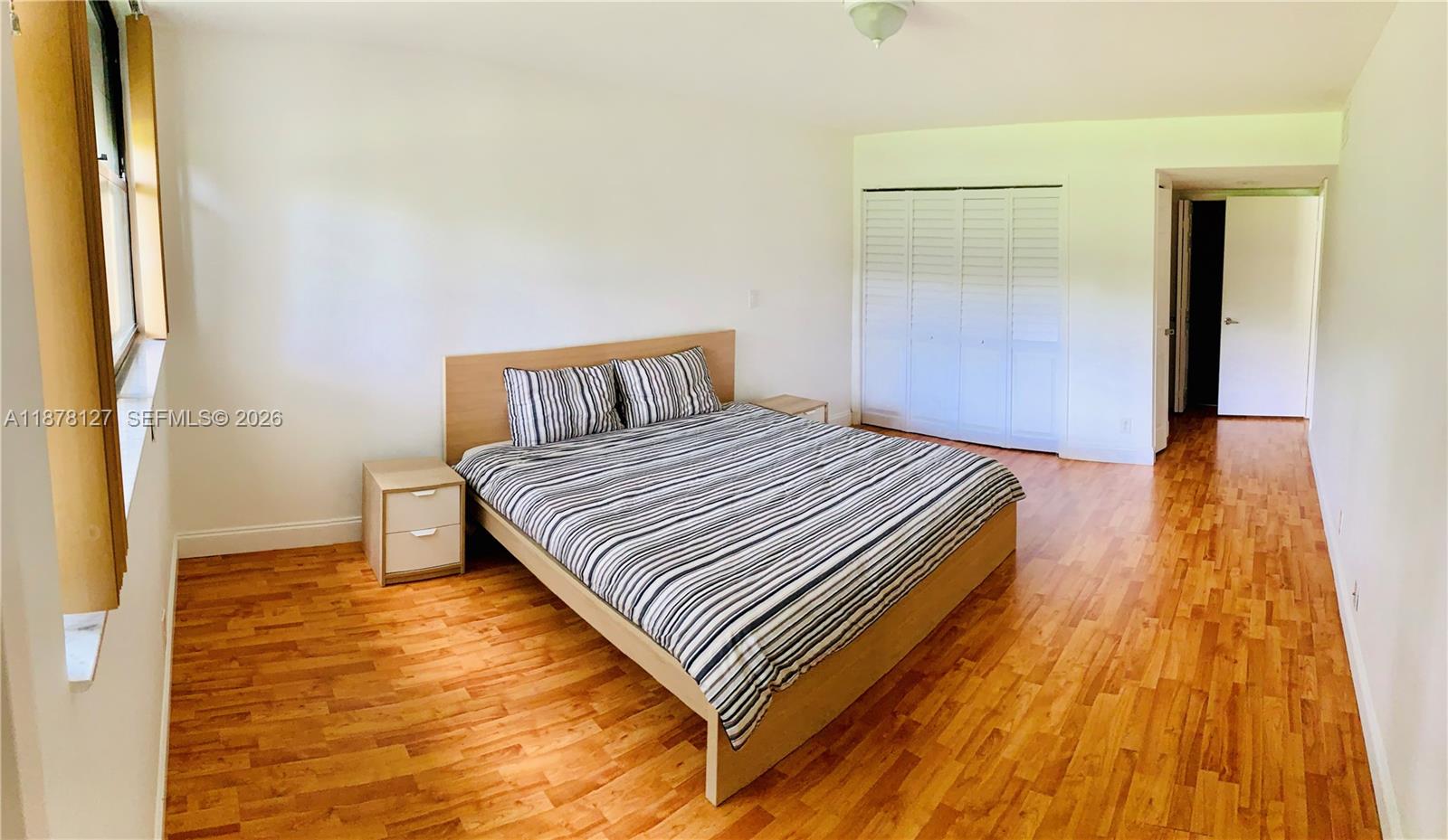 16500 Golf Club Road, Unit 101 Weston, FL 33326 - Photo 5 of 44 a spacious bedroom with a bed and wooden floor