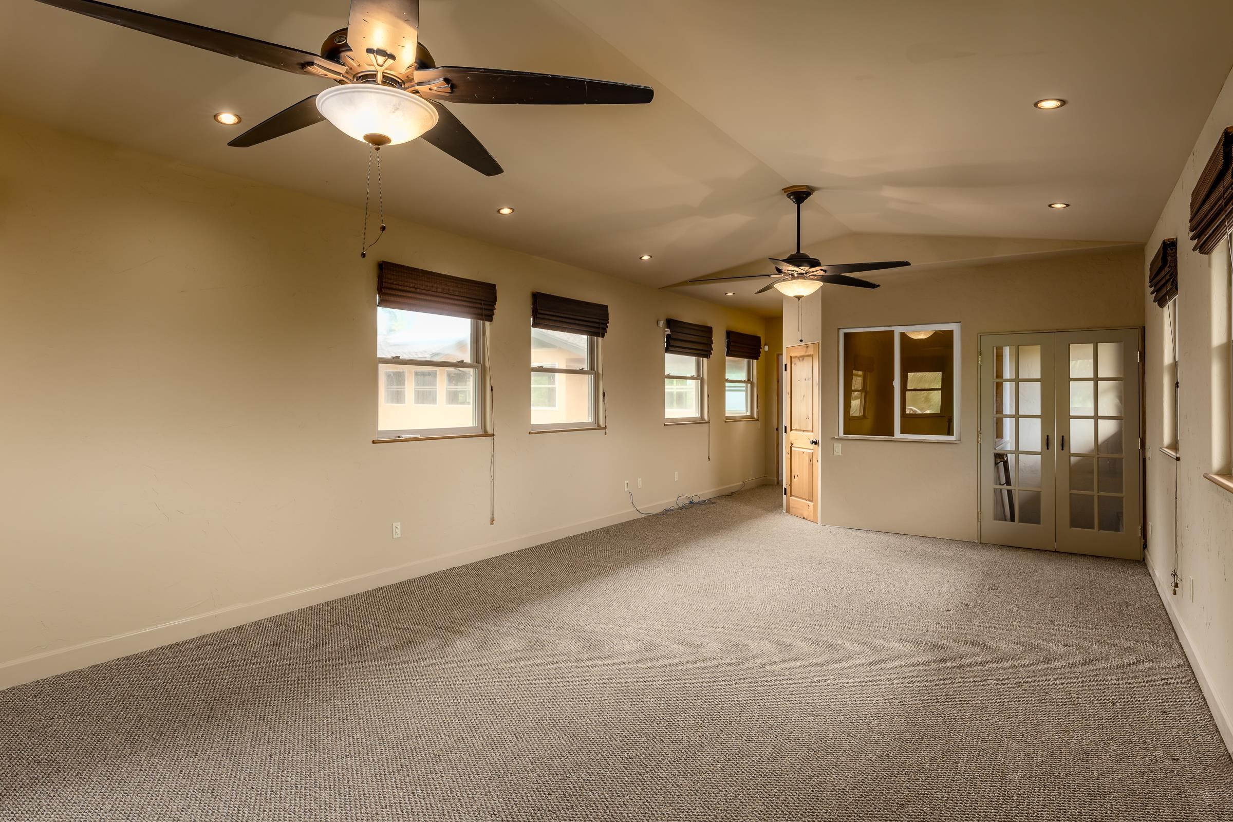 785 West Kuiaha Road Haiku, HI 96708 - Photo 28 of 49 an empty room with chandelier fan and windows