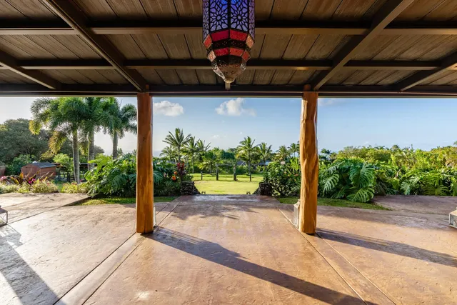 a front view of a house with a yard plants and outdoor seating