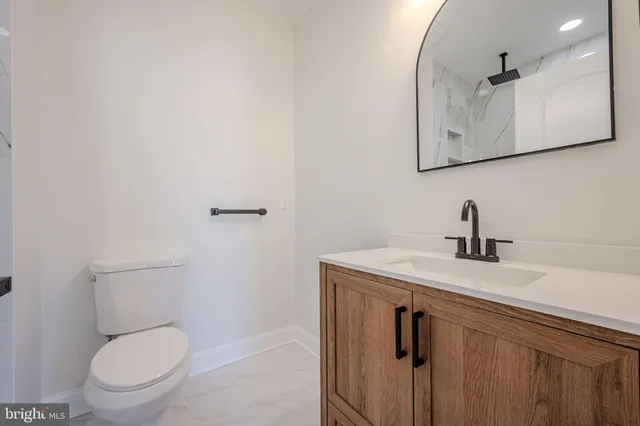a view of an empty room with chandelier fan and fire place