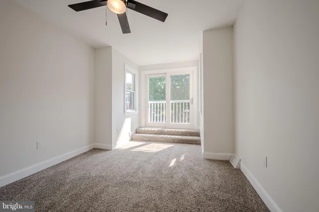 an empty room with closet and a ceiling fan