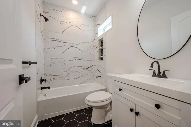 an empty room with ceiling fan and window