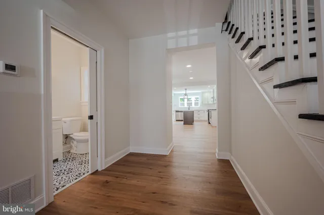 a view of a hallway with wooden floor and staircase