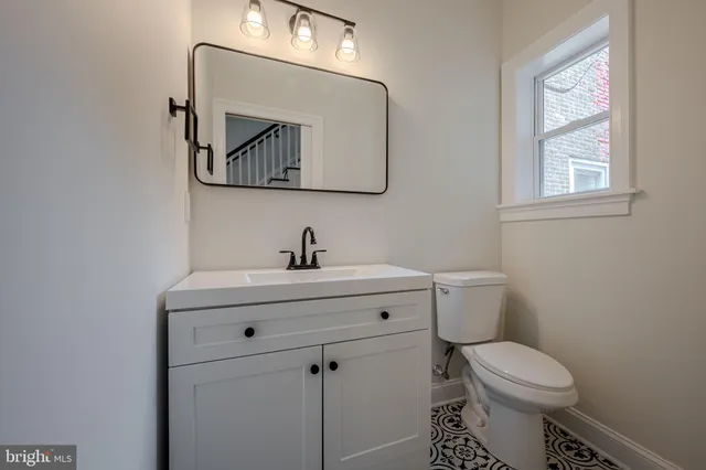 a bathroom with a toilet a sink and mirror