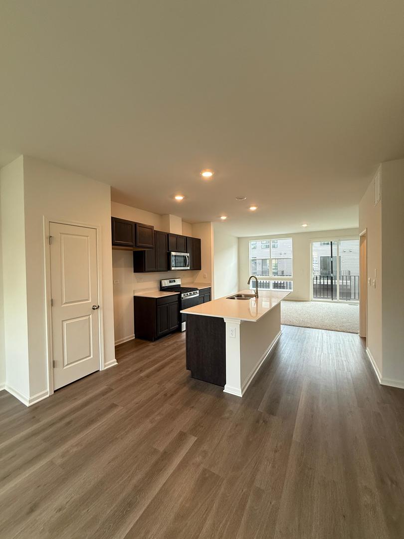347 Summit Circle Lombard, IL 60148 - Photo 3 of 18 a large living room with stainless steel appliances kitchen island wooden floors and center island