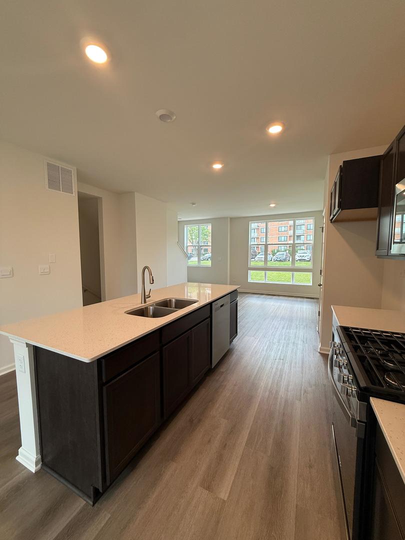 347 Summit Circle Lombard, IL 60148 - Photo 4 of 18 a large kitchen with stainless steel appliances a large counter top a stove and a wooden floors