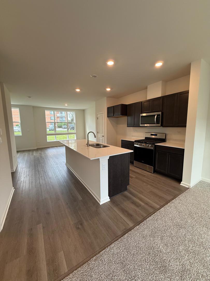 347 Summit Circle Lombard, IL 60148 - Photo 5 of 18 a large kitchen with stainless steel appliances granite countertop a stove a sink dishwasher and a microwave oven with wooden floor