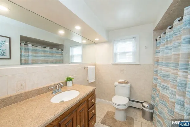 a bathroom with a granite countertop toilet a sink and a mirror