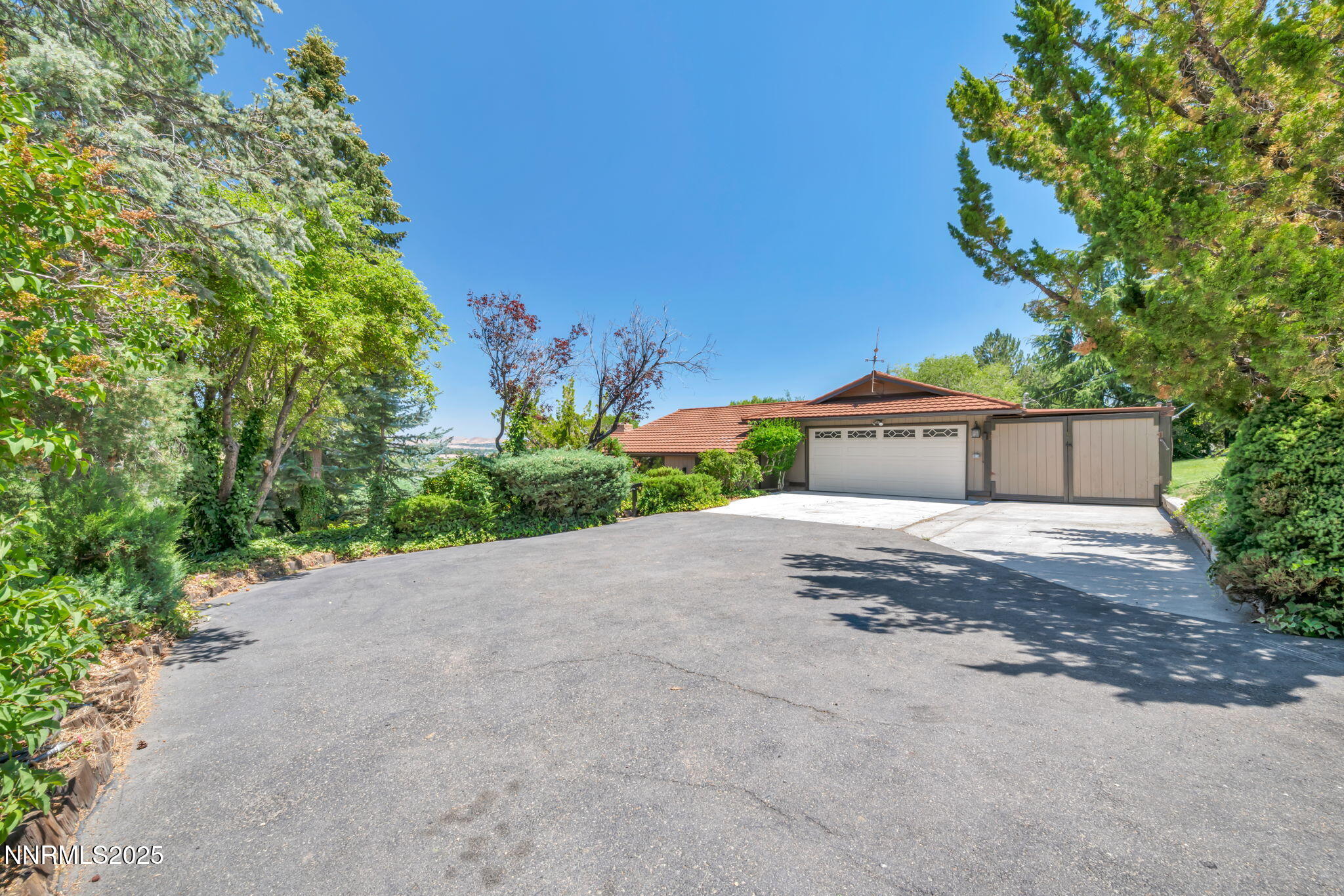 3495 West Plumb Lane Reno, NV 89509 - Photo 2 of 38 a front view of a house with a yard and garage