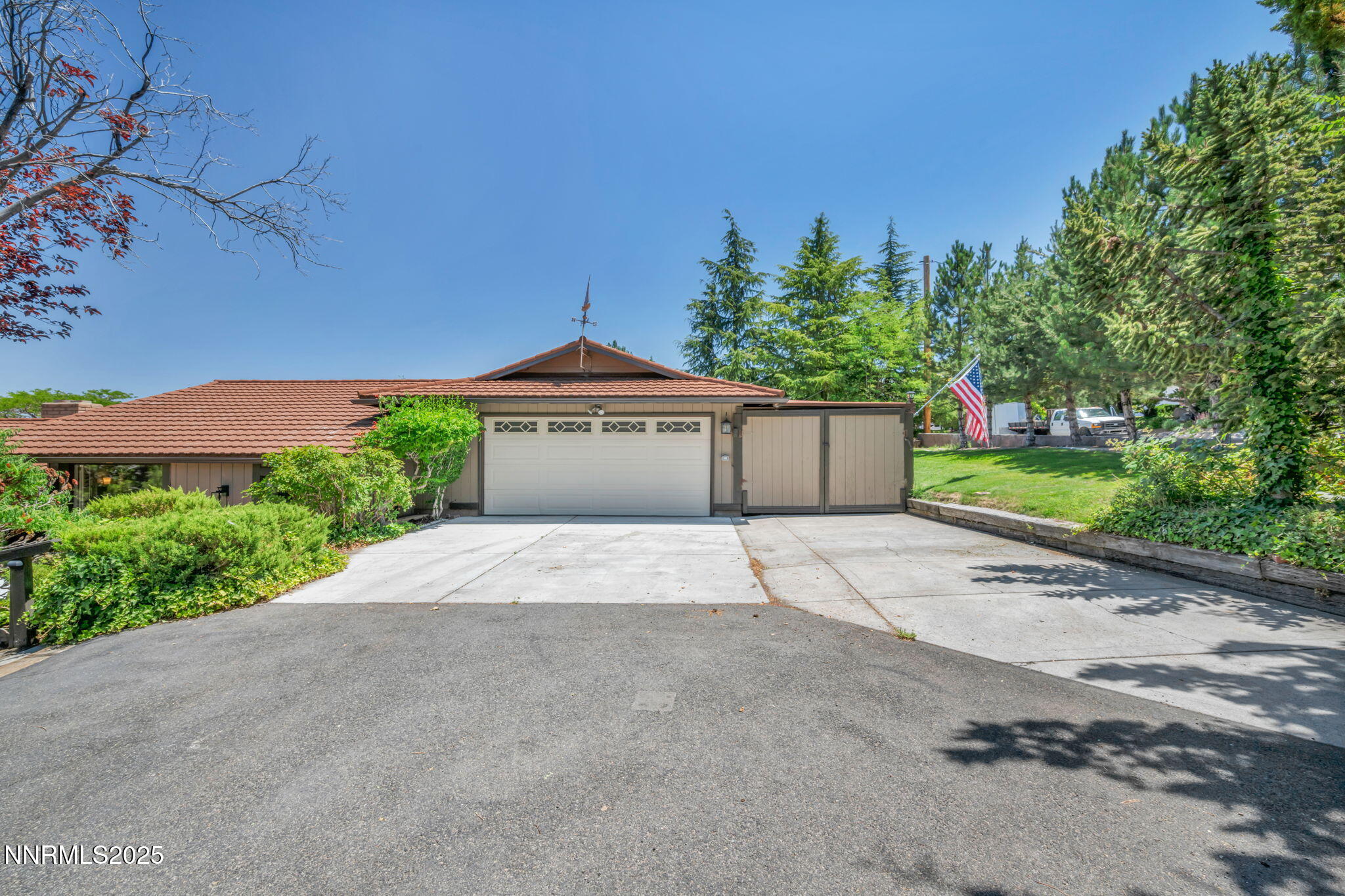 3495 West Plumb Lane Reno, NV 89509 - Photo 3 of 38 a front view of a house with a yard and a garage