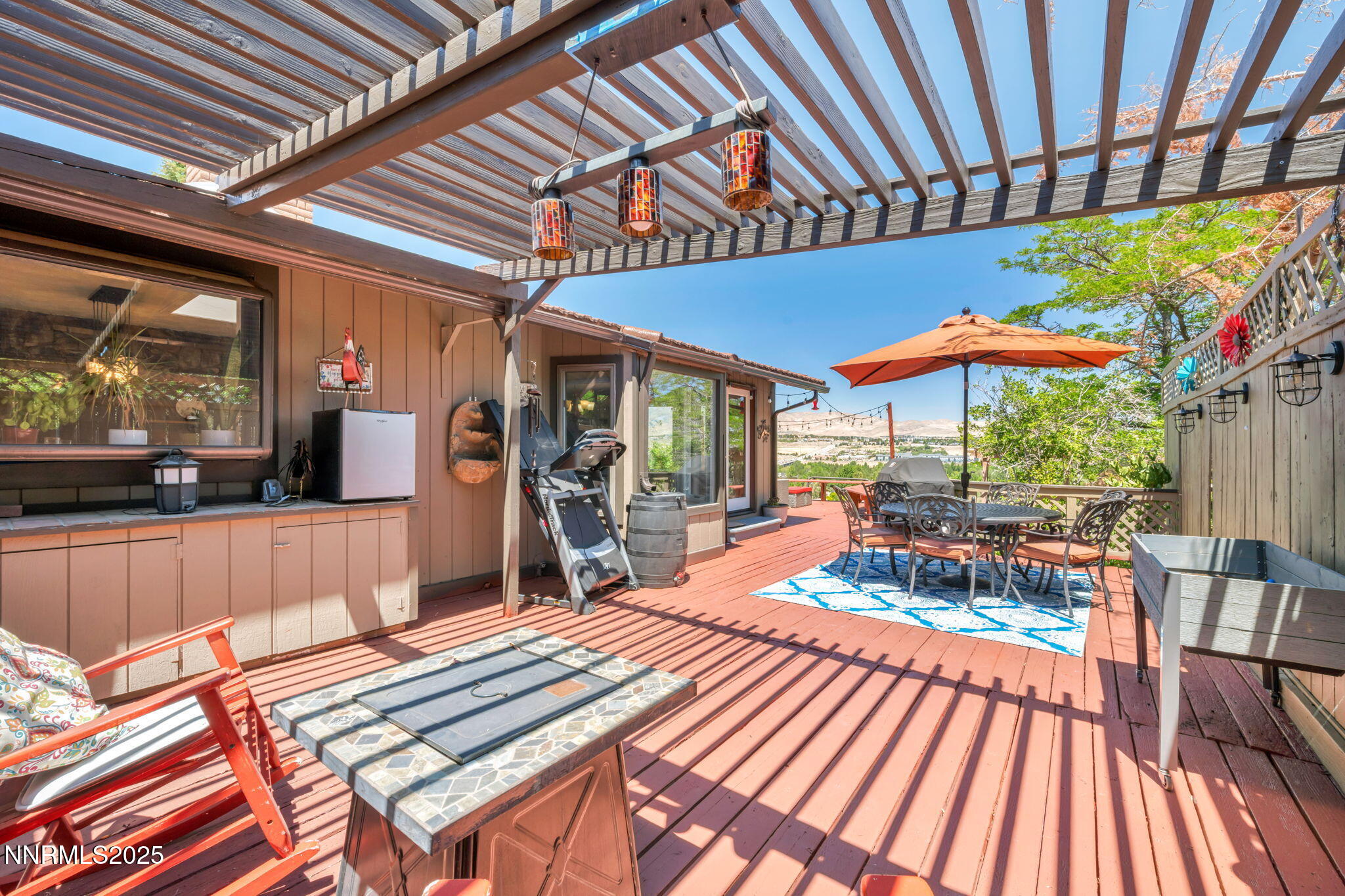 3495 West Plumb Lane Reno, NV 89509 - Photo 35 of 38 a view of a patio with a table and chairs under an umbrella with a barbeque
