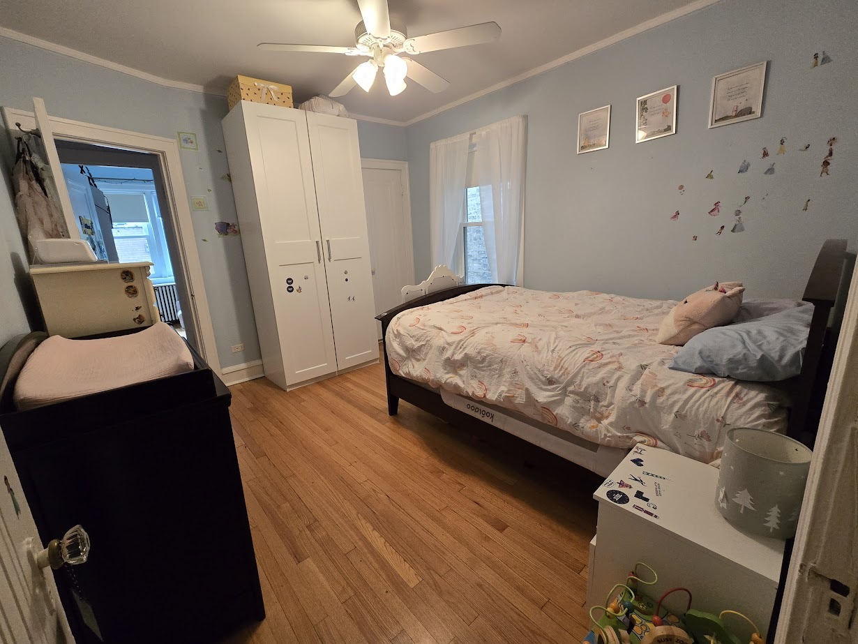 5910 North Campbell Avenue Chicago, IL 60659 - Photo 11 of 14 a bedroom with a bed and wooden floor