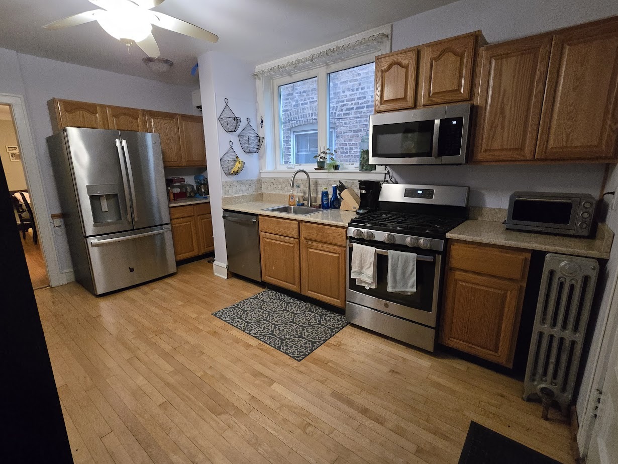 5910 North Campbell Avenue Chicago, IL 60659 - Photo 5 of 14 a kitchen with granite countertop a refrigerator stove and microwave
