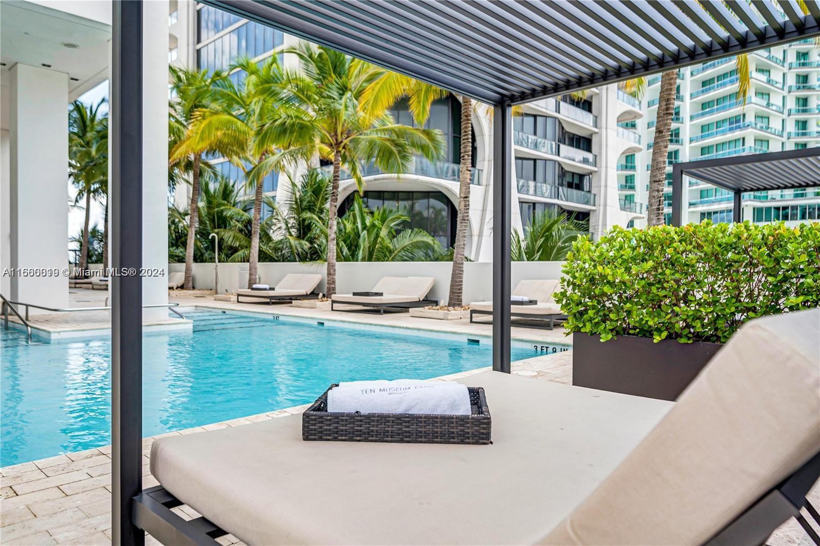 1040 Biscayne Boulevard, Unit 2607 Miami, FL 33132 - Photo 11 of 12 a view of a patio with table and chairs potted plants and floor to ceiling window