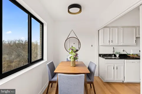 a dining room with wooden floor a glass table and chairs