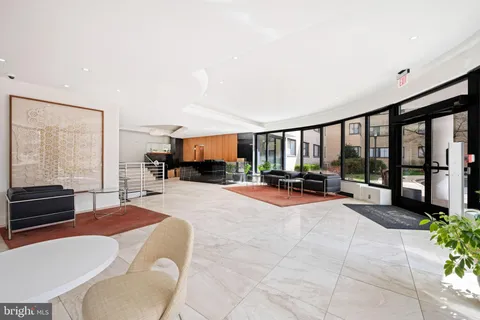 a living room with furniture a large window and kitchen view