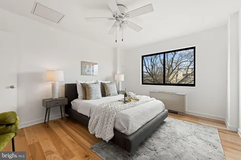 a bedroom with a bed and a painting on the wall