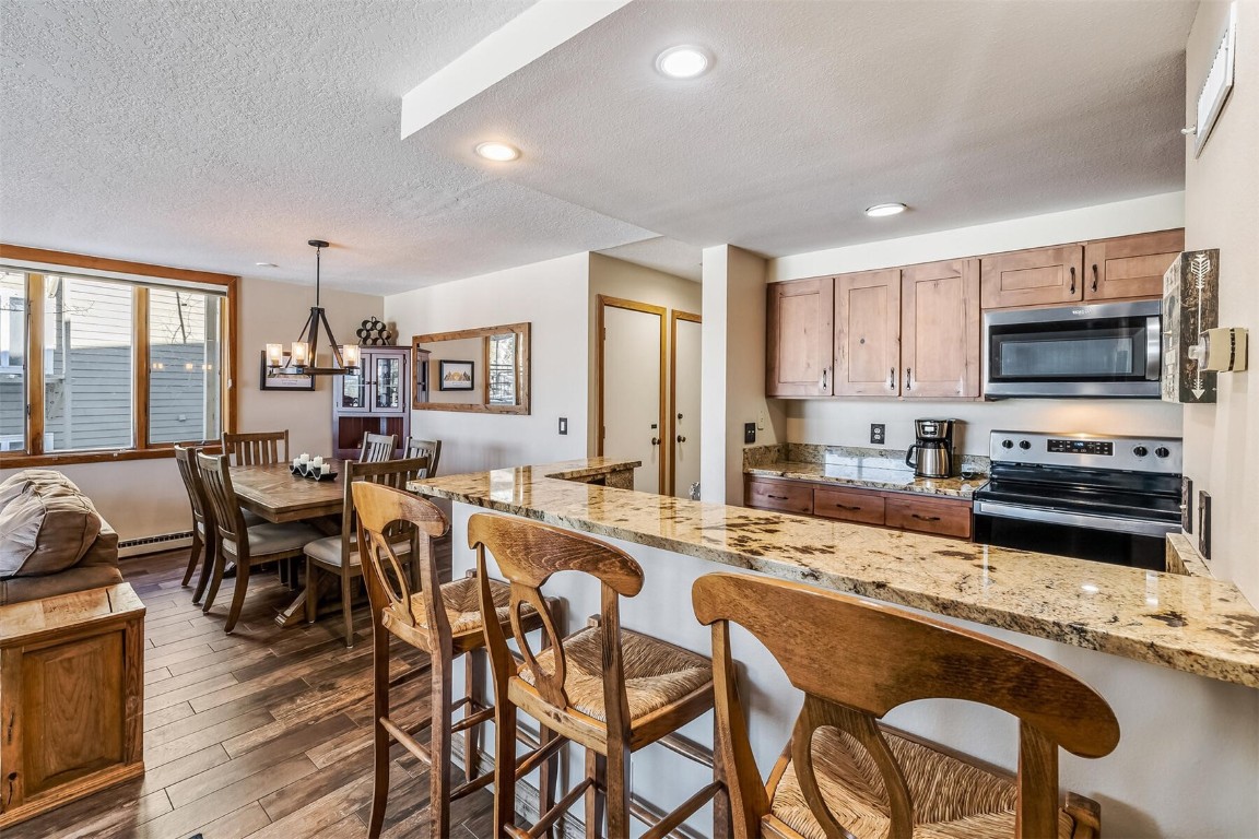 21630 Highway 6, Unit 2149 Keystone, CO 80435 - Photo 12 of 35 a living room with stainless steel appliances a dining table and chairs