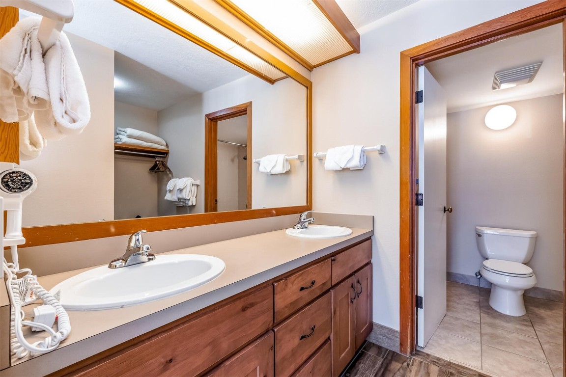 21630 Highway 6, Unit 2149 Keystone, CO 80435 - Photo 16 of 35 a bathroom with a granite countertop sink a toilet and a mirror