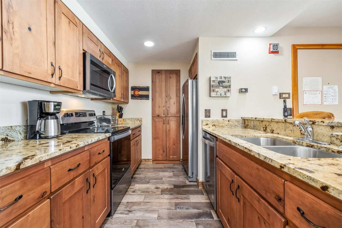 21630 Highway 6, Unit 2149 Keystone, CO 80435 - Photo 8 of 35 a kitchen with stainless steel appliances granite countertop a sink stove and refrigerator