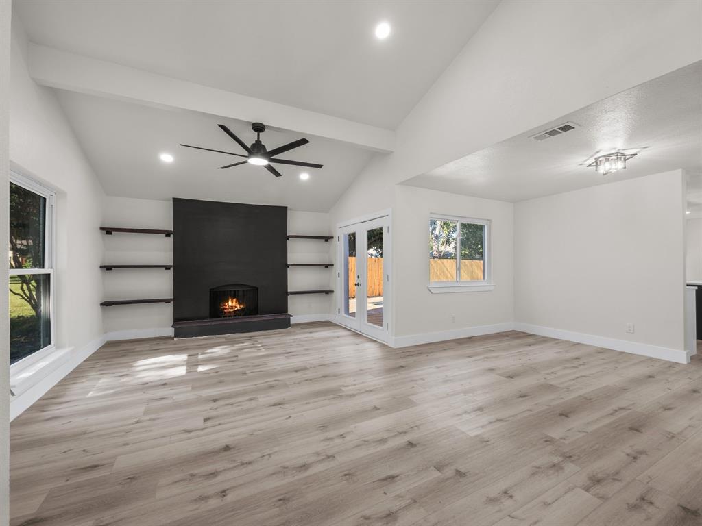 2127 Wheaton Drive Richardson, TX 75081 - Photo 11 of 33 wooden floor in an empty room with a fireplace