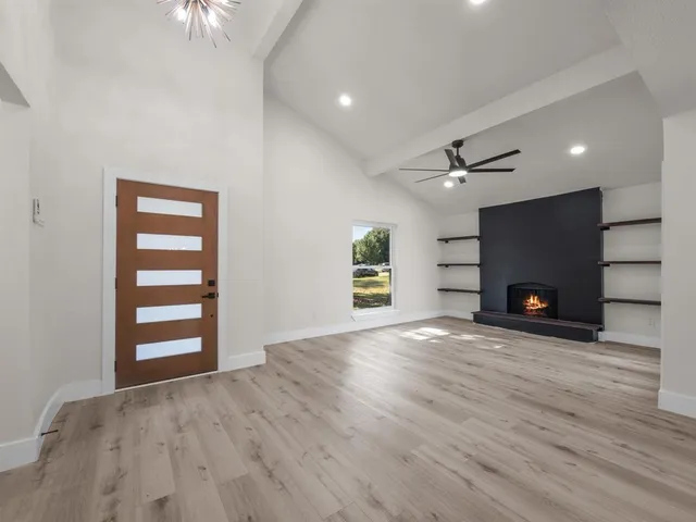 an empty room with a fireplace and wooden floor