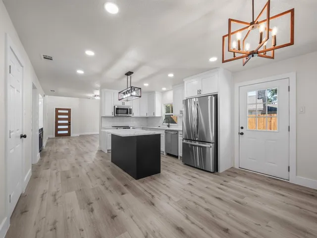 a kitchen with kitchen island a counter top space stainless steel appliances and cabinets