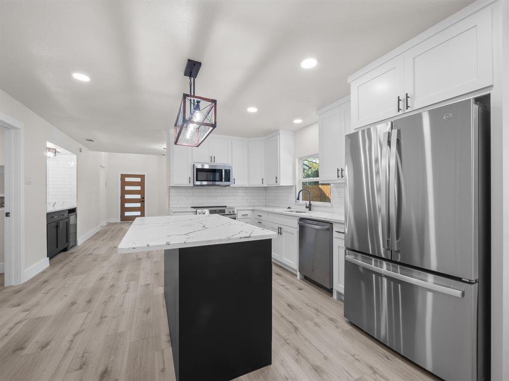 2127 Wheaton Drive Richardson, TX 75081 - Photo 19 of 33 a kitchen with kitchen island a counter top space stainless steel appliances and cabinets