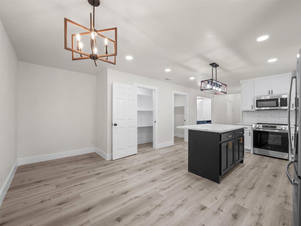 2127 Wheaton Drive Richardson, TX 75081 - Photo 20 of 33 a large kitchen with stainless steel appliances granite countertop a refrigerator a stove oven a sink dishwasher and white cabinets with wooden floor