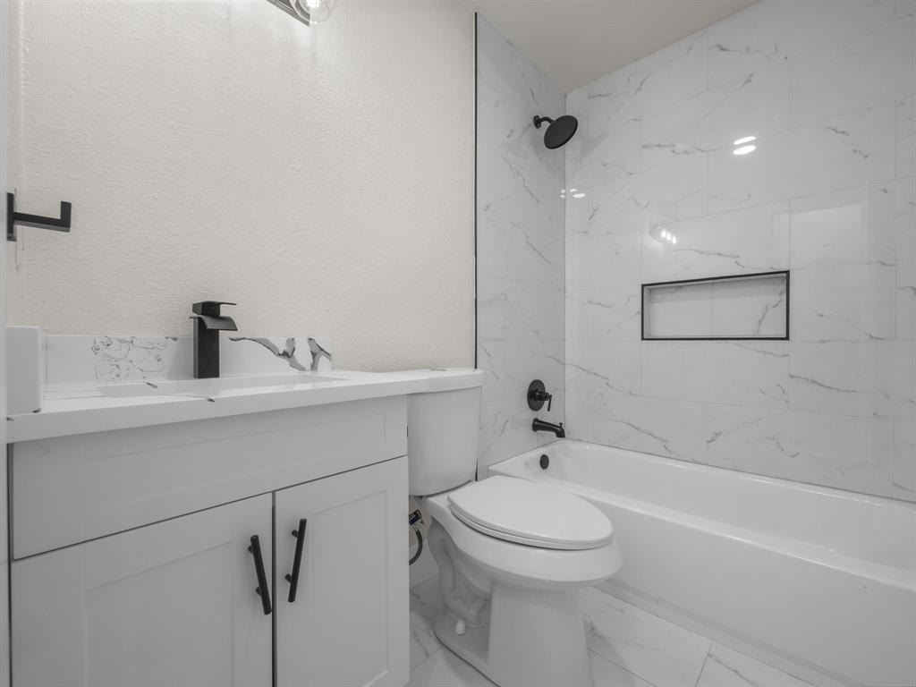 2127 Wheaton Drive Richardson, TX 75081 - Photo 26 of 33 a bathroom with a toilet sink and bathtub