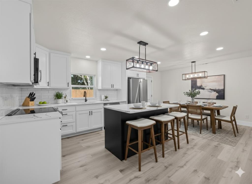 2127 Wheaton Drive Richardson, TX 75081 - Photo 6 of 33 a kitchen with a table chairs stove and cabinets