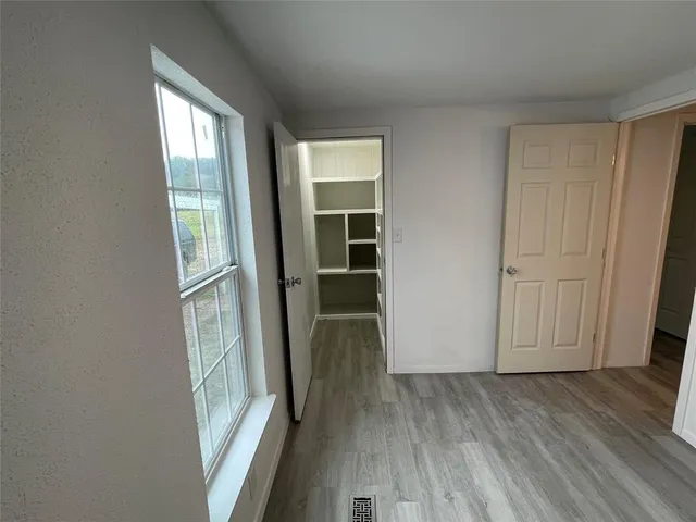 an entryway to room with wooden floor and windows