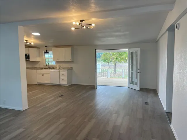 a view of a kitchen with a sink wooden cabinets and a window