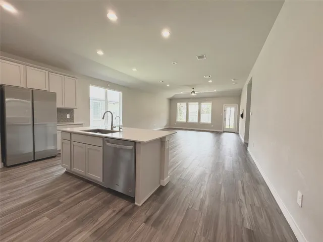 a kitchen with wooden floors and refrigerator