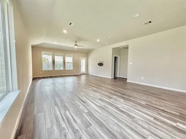 an empty room with a ceiling fan and a window