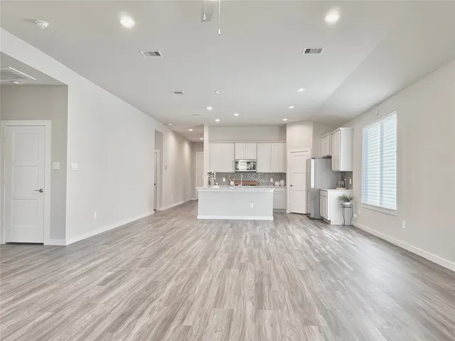 a view of a kitchen with wooden floor and electronic appliances